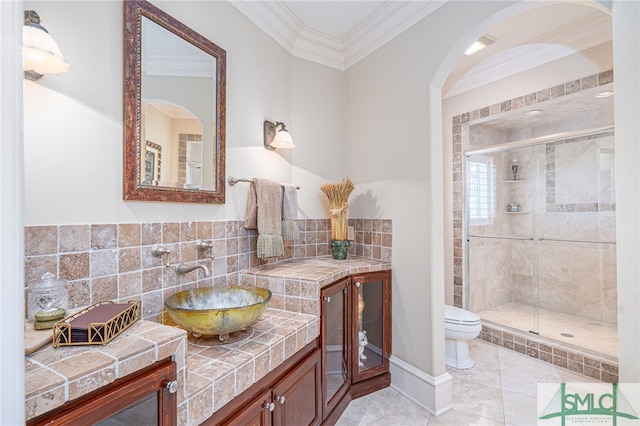 full bath featuring toilet, ornamental molding, decorative backsplash, and a shower stall