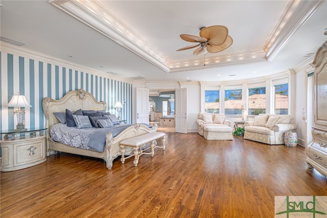 bedroom featuring a tray ceiling, crown molding, visible vents, and wood finished floors