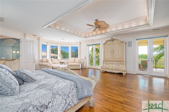 bedroom with a raised ceiling, ornamental molding, and access to outside