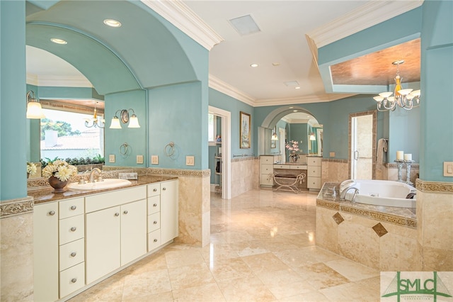 bathroom featuring a bath, vanity, a chandelier, and wainscoting