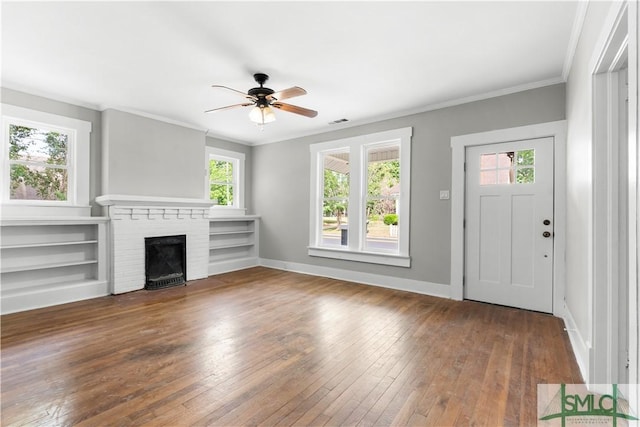 unfurnished living room with a wealth of natural light, wood-type flooring, a ceiling fan, and visible vents