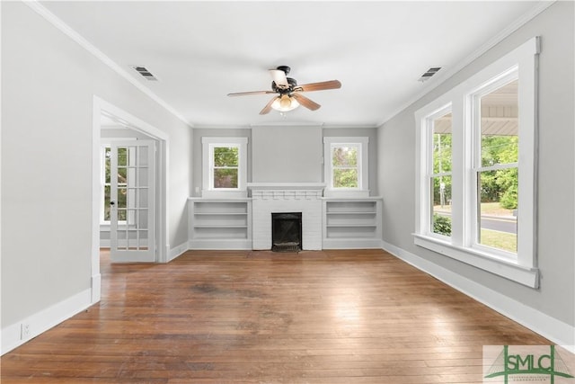 unfurnished living room featuring hardwood / wood-style flooring, ornamental molding, and visible vents