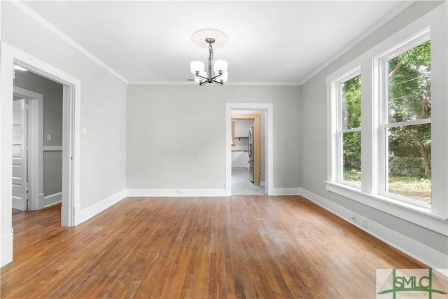 unfurnished dining area featuring ornamental molding, hardwood / wood-style flooring, a wealth of natural light, and a notable chandelier
