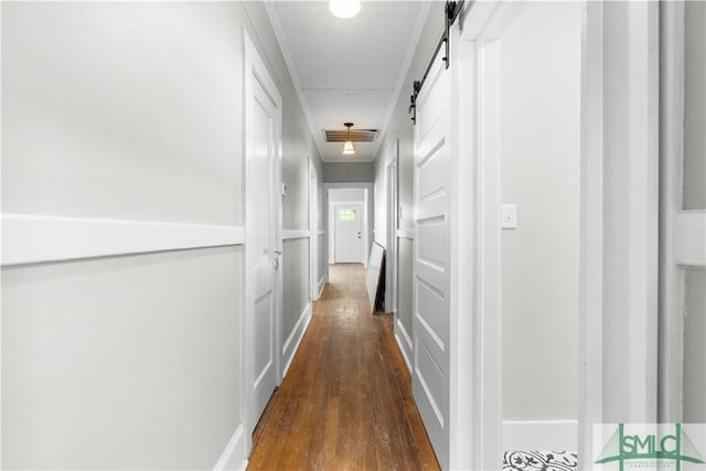 hall with dark wood finished floors, a barn door, and visible vents