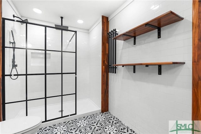 bathroom with tile patterned floors, toilet, tiled shower, and recessed lighting