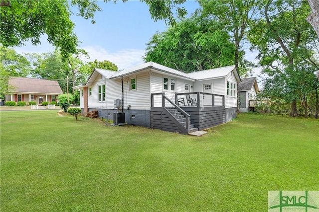 view of side of property with a lawn, stairs, a wooden deck, and central AC