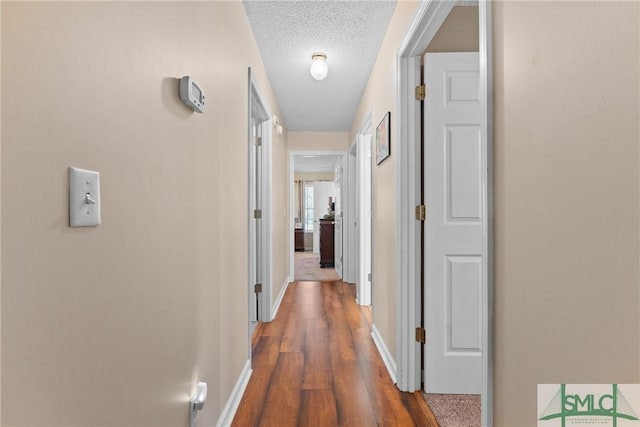 671 M P Martin Rd, Brooklet, GA 30415 - hall featuring a textured ceiling, baseboards, and wood finished floors
