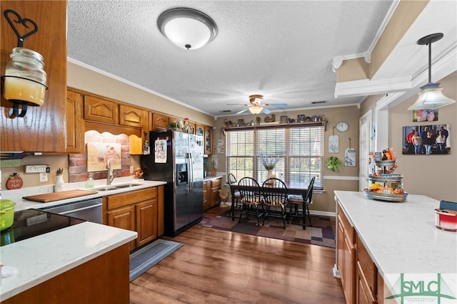 671 M P Martin Rd, Brooklet, GA 30415 - kitchen featuring a ceiling fan, a sink, brown cabinetry, refrigerator with ice dispenser, and ornamental molding
