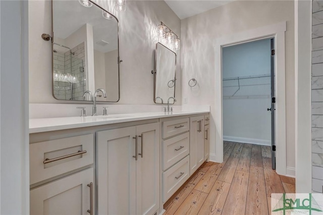 LOT10 Waters Cir, Pembroke, GA 31321 - full bathroom with double vanity, a stall shower, a sink, a spacious closet, and hardwood / wood-style flooring