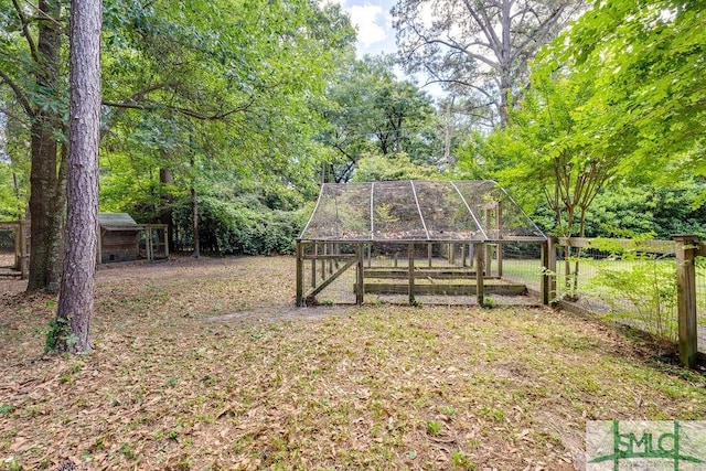 view of yard with exterior structure, fence, and an outbuilding