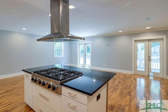 kitchen with light wood-style flooring, island range hood, stainless steel gas cooktop, and french doors
