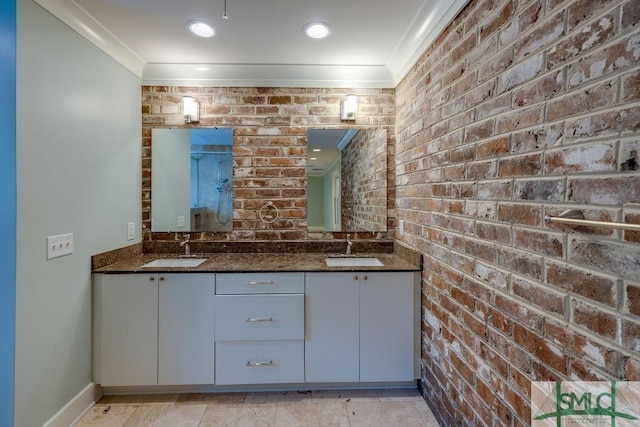 bathroom featuring a sink, double vanity, ornamental molding, and brick wall