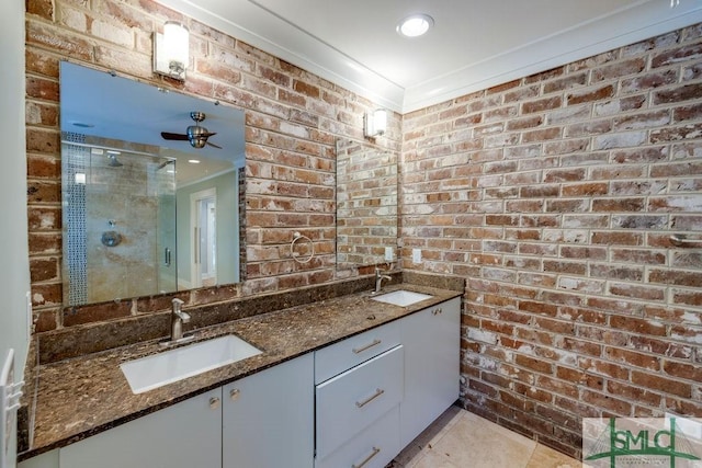 bathroom featuring a stall shower, tile patterned flooring, crown molding, and a sink