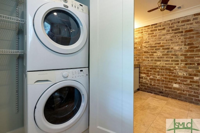 washroom with stacked washer / dryer, laundry area, light tile patterned flooring, ceiling fan, and brick wall