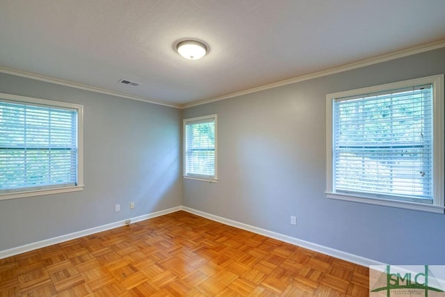 empty room featuring baseboards, visible vents, and crown molding