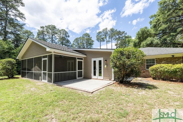 back of property with a yard, a sunroom, a patio, and french doors