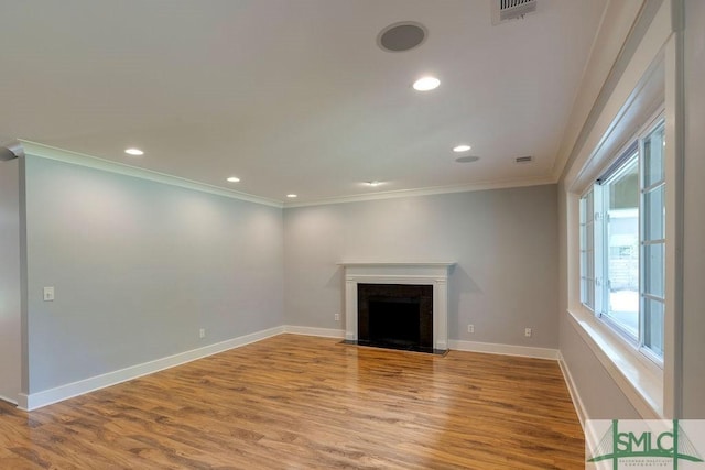 unfurnished living room with a fireplace, light wood-type flooring, visible vents, baseboards, and ornamental molding