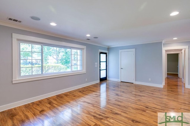 spare room with baseboards, recessed lighting, crown molding, and wood finished floors