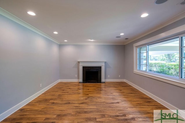 unfurnished living room with ornamental molding, wood finished floors, baseboards, and recessed lighting