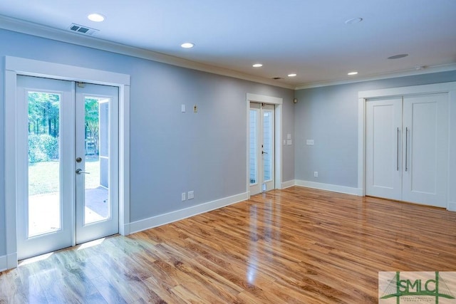 spare room with french doors, wood finished floors, recessed lighting, crown molding, and baseboards