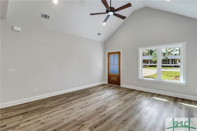 empty room featuring visible vents, wood finished floors, a ceiling fan, and high vaulted ceiling