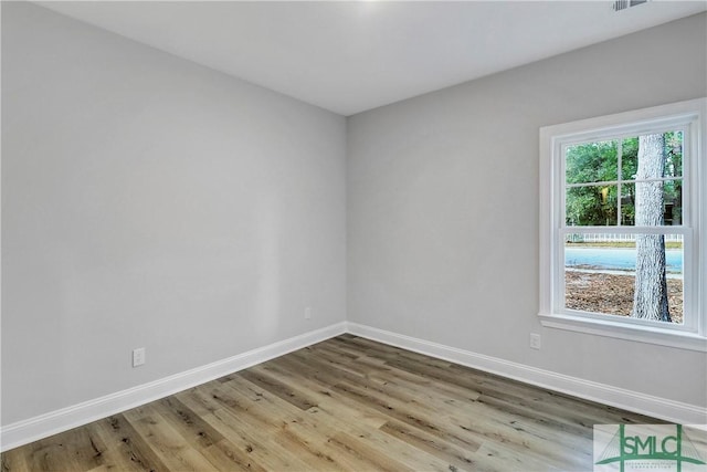 spare room featuring wood finished floors and baseboards
