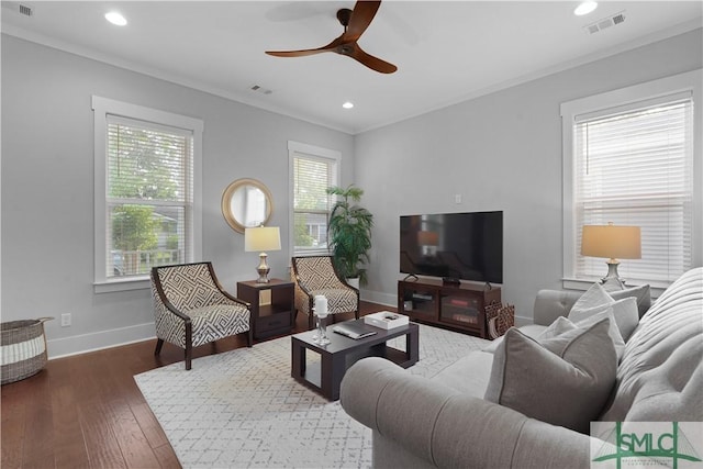 living area featuring baseboards, a ceiling fan, visible vents, and wood finished floors