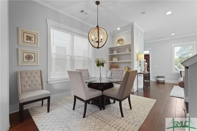 dining space featuring baseboards, visible vents, a chandelier, and crown molding
