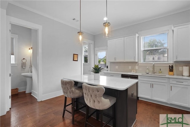 kitchen with white cabinets, light countertops, dark wood finished floors, and a sink