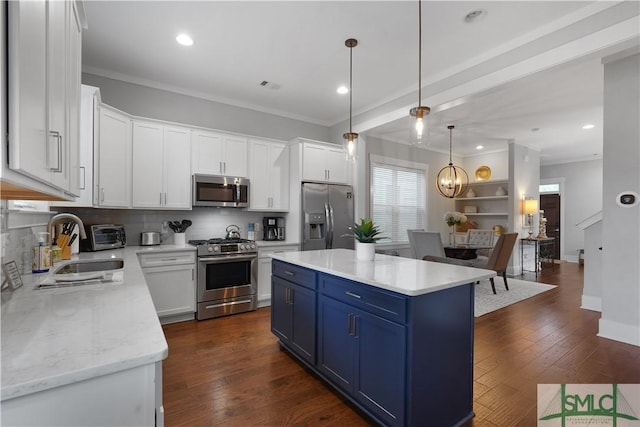 kitchen with a sink, white cabinets, appliances with stainless steel finishes, decorative backsplash, and blue cabinetry
