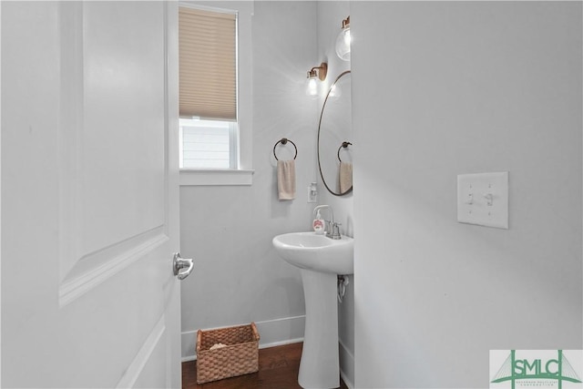 bathroom with wood finished floors, baseboards, and a sink