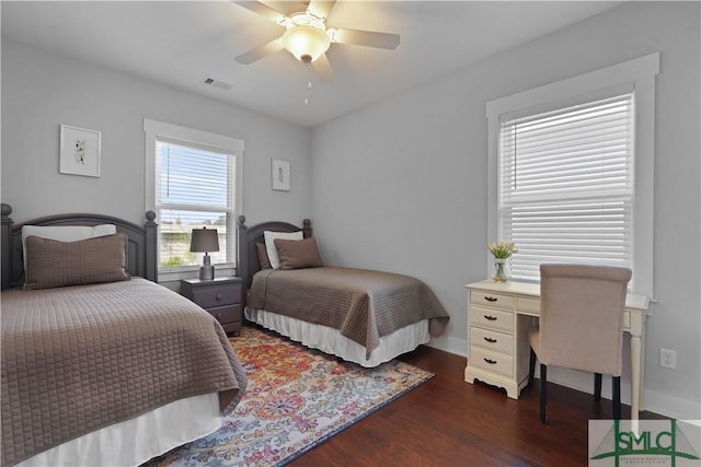 bedroom with baseboards, dark wood finished floors, visible vents, and a ceiling fan