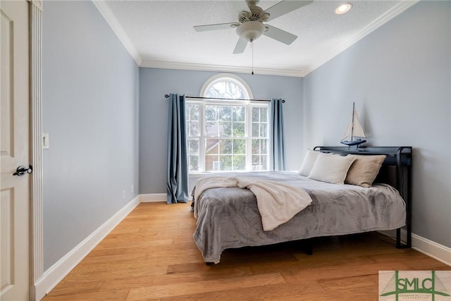 bedroom with light wood finished floors, ornamental molding, baseboards, and recessed lighting