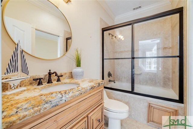 full bath with toilet, combined bath / shower with glass door, visible vents, vanity, and ornamental molding