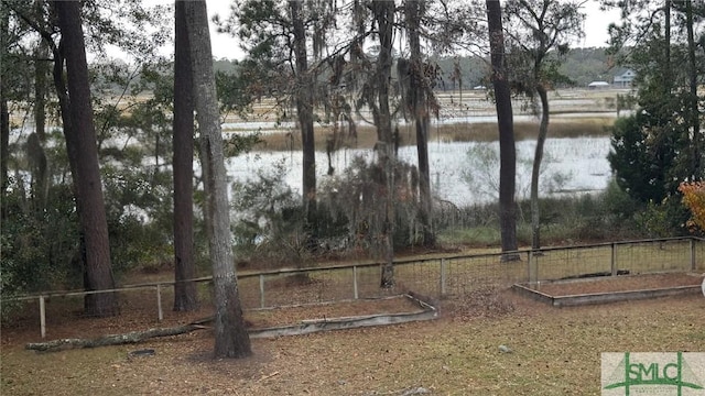 view of yard with a water view and fence