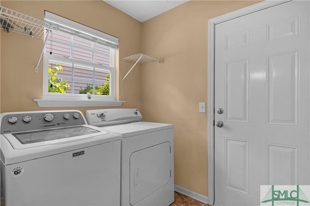 clothes washing area featuring tile patterned floors, laundry area, washer and clothes dryer, and baseboards