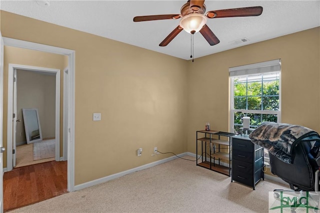 home office with ceiling fan, light carpet, baseboards, and visible vents