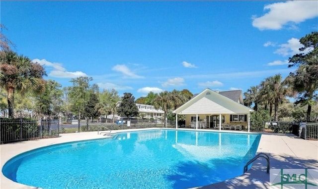 community pool with a patio and fence