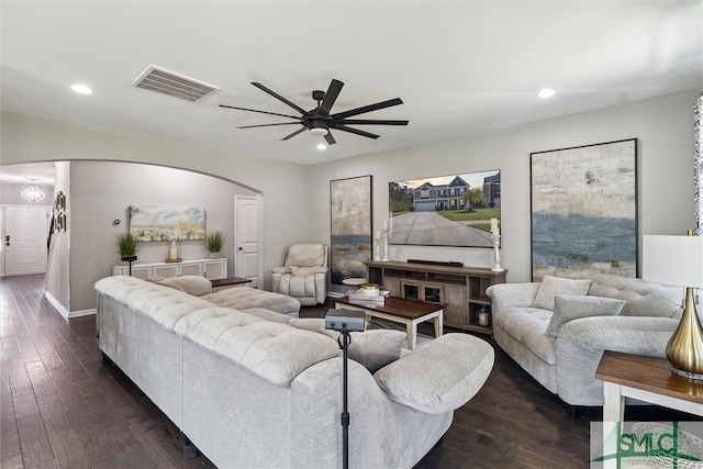 living room with arched walkways, visible vents, and recessed lighting