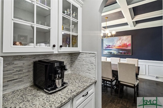 bar featuring a notable chandelier, coffered ceiling, dark wood-type flooring, tasteful backsplash, and beam ceiling