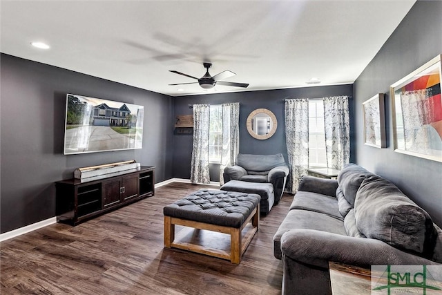 living area with ceiling fan, baseboards, and dark wood-style floors