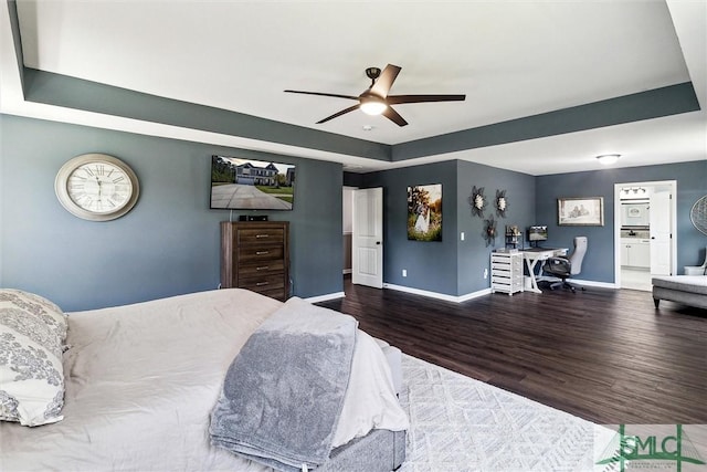 bedroom with baseboards, a tray ceiling, a ceiling fan, and wood finished floors