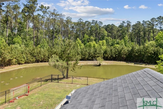 view of community with a yard, a water view, and fence