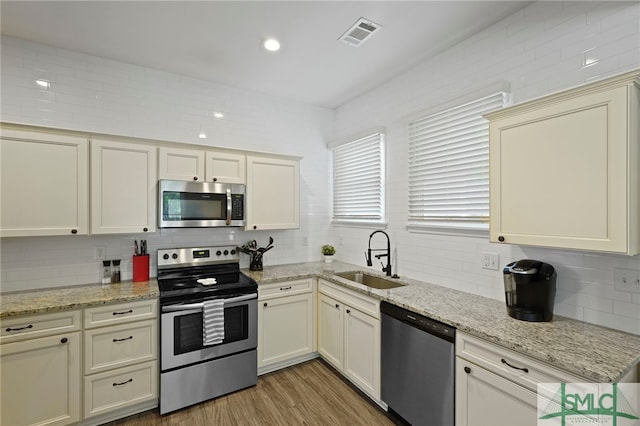 856 E 35th St, Savannah, GA 31401 - kitchen with a sink, appliances with stainless steel finishes, visible vents, backsplash, and light wood-style floors
