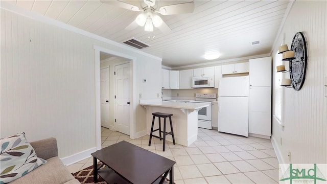 856 E 35th St, Savannah, GA 31401 - kitchen featuring white appliances, a peninsula, a kitchen bar, light countertops, and white cabinetry
