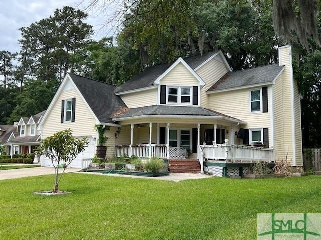 view of front facade featuring a front lawn, a porch, a chimney, and a garage