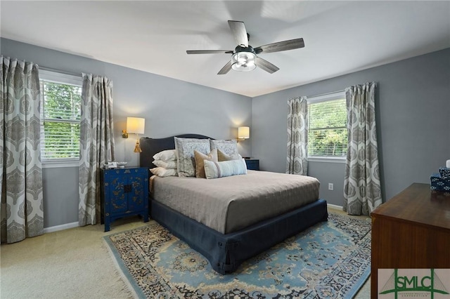 carpeted bedroom with multiple windows, baseboards, and a ceiling fan