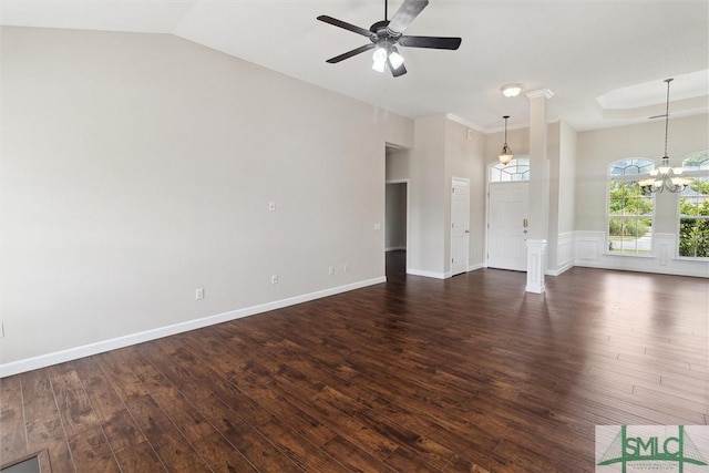 unfurnished living room featuring a wainscoted wall, dark wood-type flooring, lofted ceiling, and ceiling fan with notable chandelier