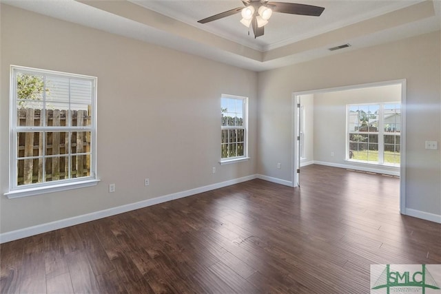 spare room featuring a ceiling fan, baseboards, visible vents, crown molding, and dark wood-type flooring