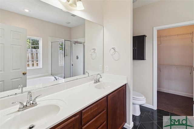 bathroom with a shower stall, tile patterned flooring, toilet, and a sink